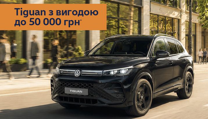 Чорний Volkswagen Tiguan на міській вулиці з банером про знижку до 50 000 гривень